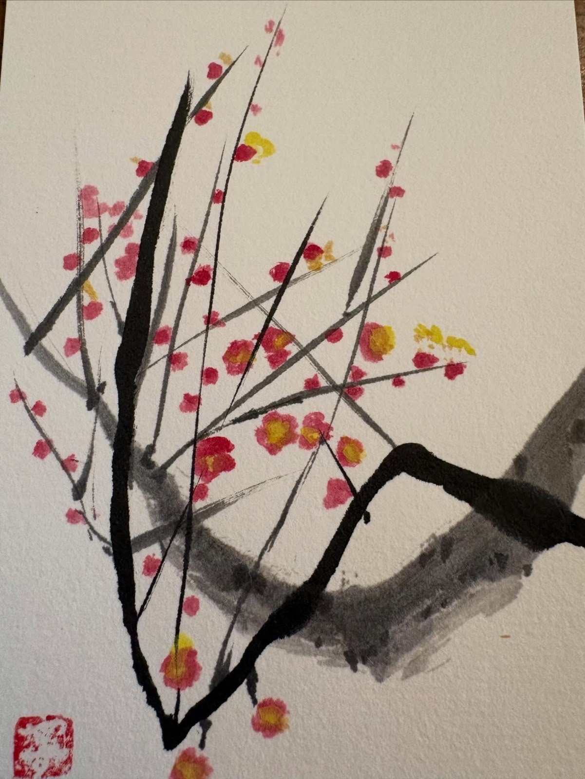紅い梅の花が咲く枝を描いた作品